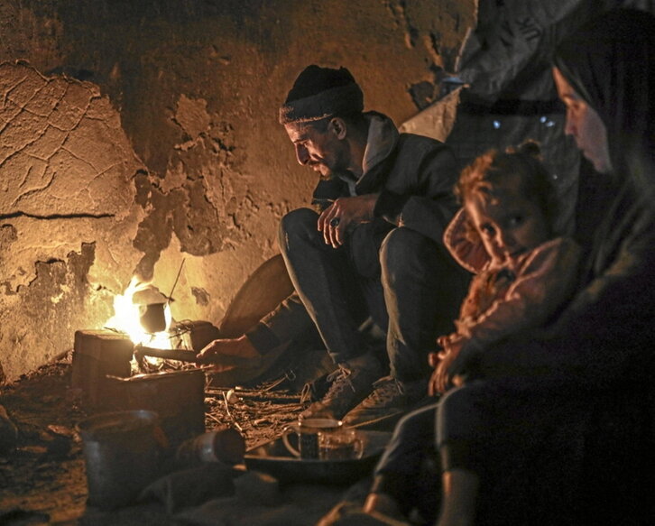 Una famalia se calienta en Gaza.