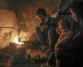 Una famalia se calienta en Gaza.