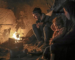 Una famalia se calienta en Gaza.