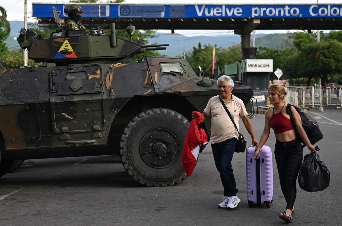 Dos personas cruzan la frontera entre Venezuela y Colombia. (Raul ARBOLEDA/AFP)