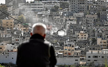Residentes del campo de refugiados de Nur Shams observan cómo una excavadora militar israelí derriba sus casas.