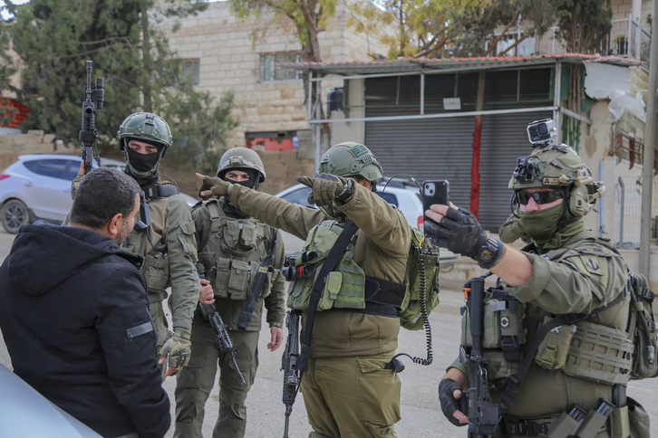 Soldados israelíes hostigan a un palestino en un control cerca de Hebrón.