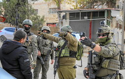 Soldados israelíes hostigan a un palestino en un control cerca de Hebrón.