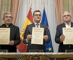 Los firmantes del acuerdo muestran el documento.