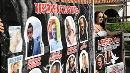 Una mujer se manifiesta en Cúcuta por la liberación de los colombianos presos en Venezuela mostrando las fotografías de algunos de ellos.