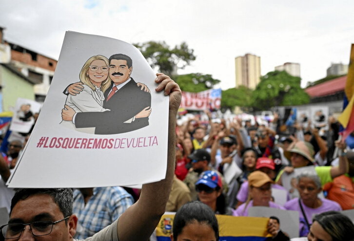 Un manifestante sostiene un cartel en Caracascon la imagen de Maduro y Flores.