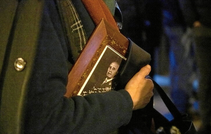 Emakume bat Francoren erretratua eskuetan, haren omenez Madrilen iazko azaroaren 20an egindako mezan.