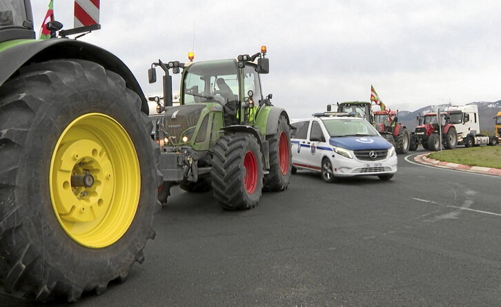 Un coche de la Ertzaintza entre tractores en una rotonda de acceso a la A-1 en Durruma.