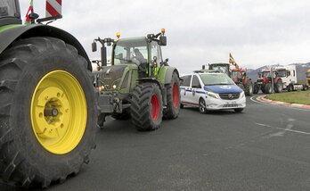 Un coche de la Ertzaintza entre tractores en una rotonda de acceso a la A-1 en Durruma.