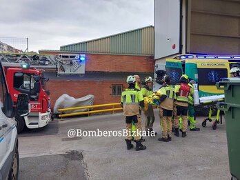 Bomberos trasladan al herido a la ambulancia.