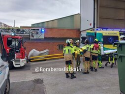 Bomberos trasladan al herido a la ambulancia.