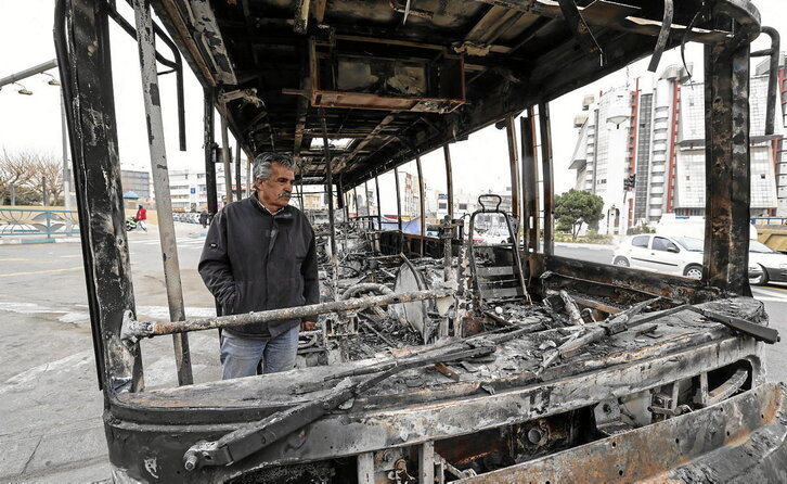Un hombre junto a los restos de un autobús quemado en la plaza Sadeghieh de Teherán, el 15 de enero de 2026.
