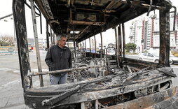 Un hombre junto a los restos de un autobús quemado en la plaza Sadeghieh de Teherán, el 15 de enero de 2026.