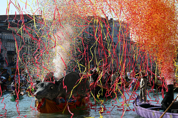 Los confetis explotan mientras los barcos decorados navegan por el Gran Canal durante el tradicional desfile.