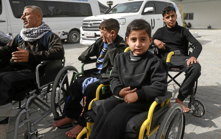 Palestinos esperan en silla de ruedas a ser evacuados de la Franja de Gaza.