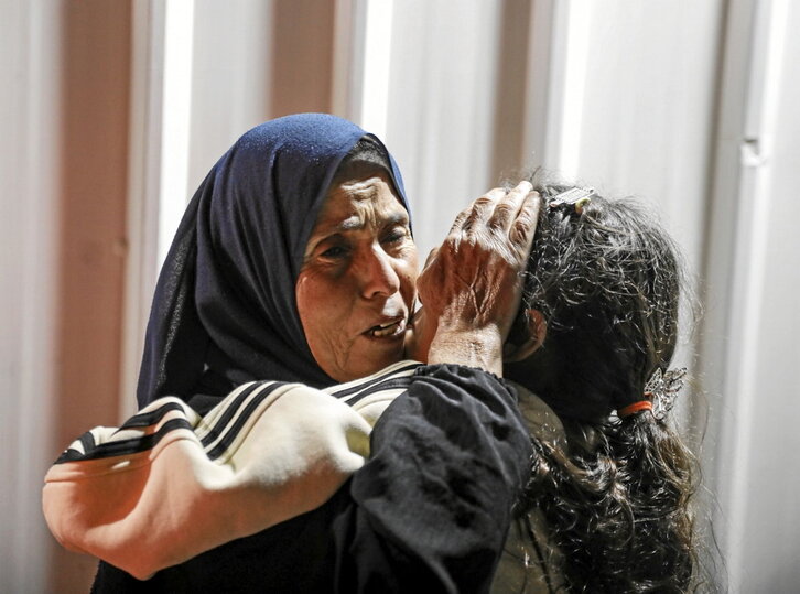 Una mujer palestina abraza a su hija tras regresar a Gaza.