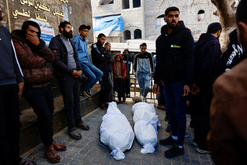 Palestinos, junto a los cuerpos de dos de las víctimas en el bombardeo de Ciudad de Gaza.