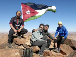 Abajo, la expedición, en la cima del Jabal Umm al Dami. En la otra página, haciendo escalada interior junto a niños palestinos refugiados y el guía Jarah Alhawamdeh ascendiendo con muletas.