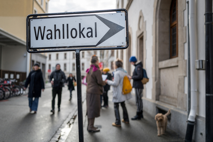 Un cartel indica la entrada a un centro de votación en Suiza.