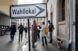 Un cartel indica la entrada a un centro de votación en Suiza.