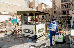 Un hombre camina con bolsas entre los escombros de un edificio destruido en un ataque con misiles en Teherán.