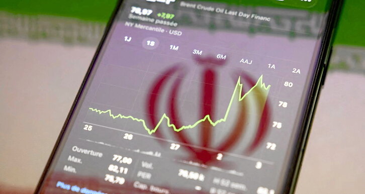 Cotización del petróleo Brent, en la pantalla de un teléfono con el reflejo de la bandera iraní.