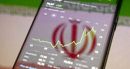 Cotización del petróleo Brent, en la pantalla de un teléfono con el reflejo de la bandera iraní.