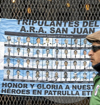 Bandera argentina con los rostros de la tripulación.