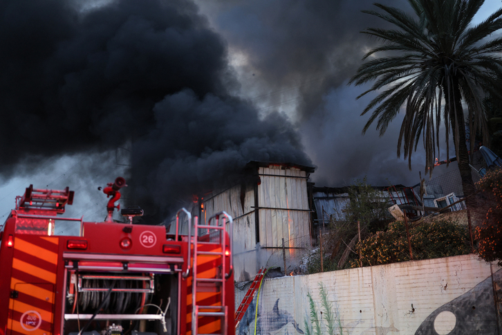 Los bomberos apagan el fuego provocado por el Impacto de un proyectil iraní en las afueras de Tel Aviv.