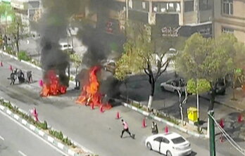 Motocicleta en llamas tras un ataque a un puesto de control de las milicias Basij en Teherán.