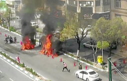 Motocicleta en llamas tras un ataque a un puesto de control de las milicias Basij en Teherán.