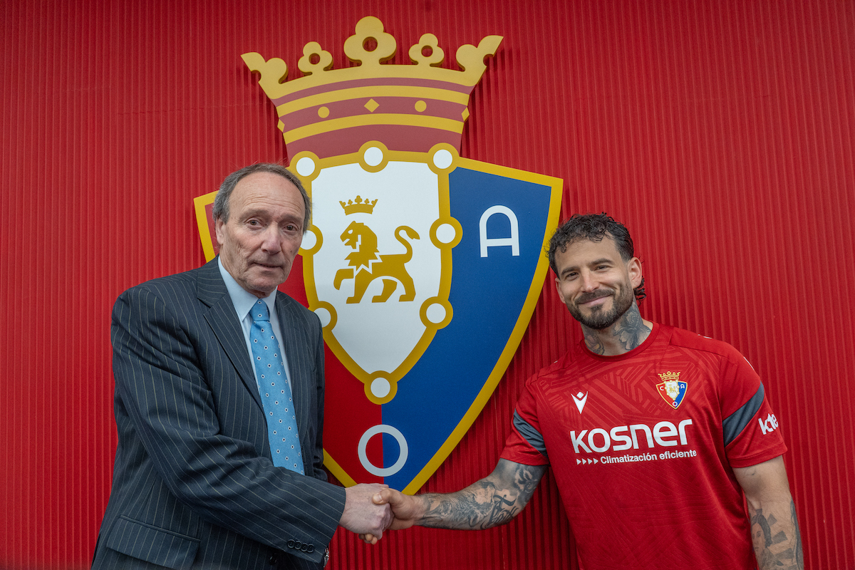 Javier Castañeda y Rubén García estrechan sus manos junto al escudo rojillo. (Andoni CANELLADA | FOKU)