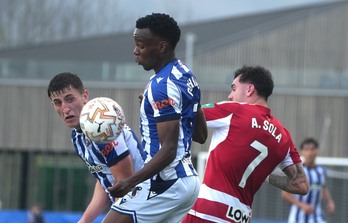 Ochieng y Mariezkurrena pugna con un ex txuriurdin, Alex Sola, este domingo en Zubieta.