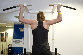 Pertsona bat gimnasioan ariketak egiten, artxiboko irudian.