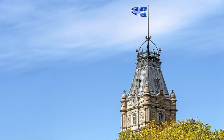 Quebeceko bandera hiriko Parlamentuaren eraikinaren goialdean. (Marc Bruxelle | Getty Images)