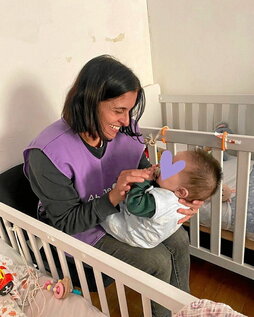 Abrázame Fundazioko boluntario bat, haurtxo bati mimoak ematen.