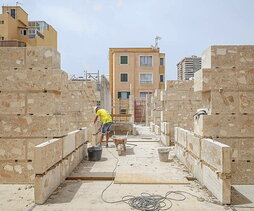 Abajo, el proceso de ejecución de los muros durante la obra.En la siguiente página, las fachadas de las viviendas sociales.