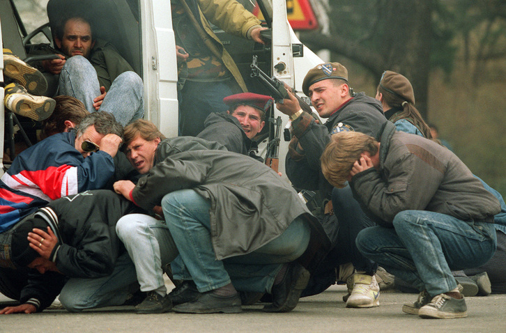Civiles se refugian de francotiradores en Sarajevo en 1992.