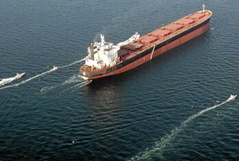 Embarcaciones maniobrando alrededor de un buque cisterna durante un ejercicio militar realizado por miembros del CGRI.