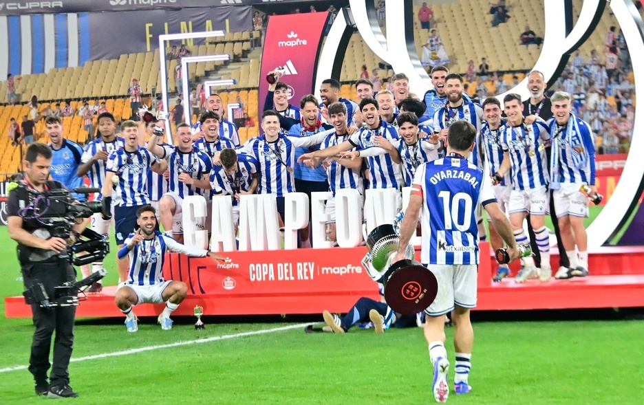 Oyarzabal, Copa en mano, camina hacia sus compañeros para la foto de familia.