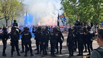 Decenas de policías, algunos a caballo, por delante de la kalejira blanquiazul.