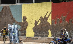 Un motociclista pasa junto a un monumento en apoyo al Ejército de Malí en Bamako el 26 de abril de 2026..