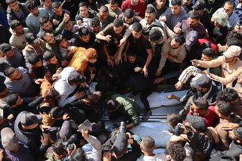 Palestinos rodean los cuerpos de muertos el martes en un ataque israelí en Ciudad de Gaza.