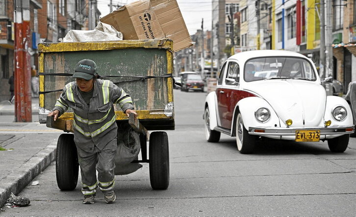 Una recicladora informal tirando de la mercancia recogida en las calles de Bogotá.
