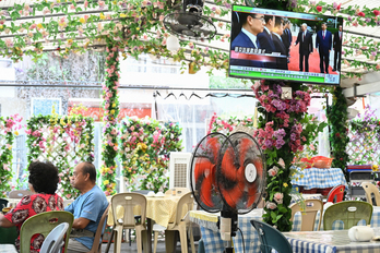 Un televisor de un restaurante de Hong Kong retransmite la imagen del encuentro.