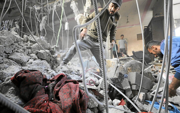 Palestinos inspeccionan sus casas destruidas tras un bombardeo israelí en la noche del miércoles en el campo de refugiados de Al-Maghazi, en el centro de la Franja de Gaza.