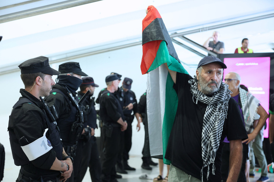 Bandera palestina ante la línea policial. 