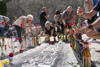 Asistentes al homenaje depositan botellas y claveles frente al fuerte.