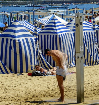 Un hombre se refresca en la playa.