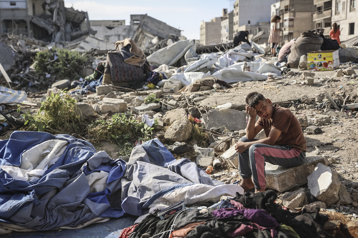Un niño, sobre los restos de un edificio bombardeado por Israel en Ciudad de Gaza, en el que han muerto deiz personas.